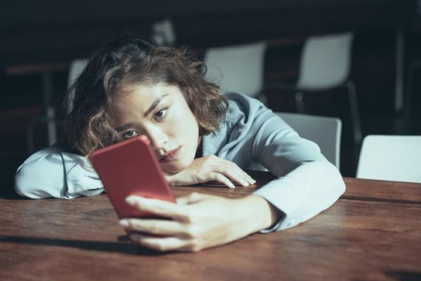 sad young woman holding phone