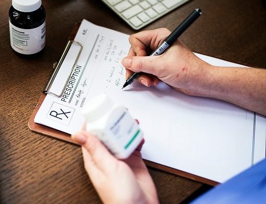 Person filling out prescription form